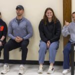 Four teachers doing wall squats.