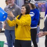 A teacher catches a blue bucket in the air.