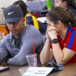 Two teachers talking to each other at a table.